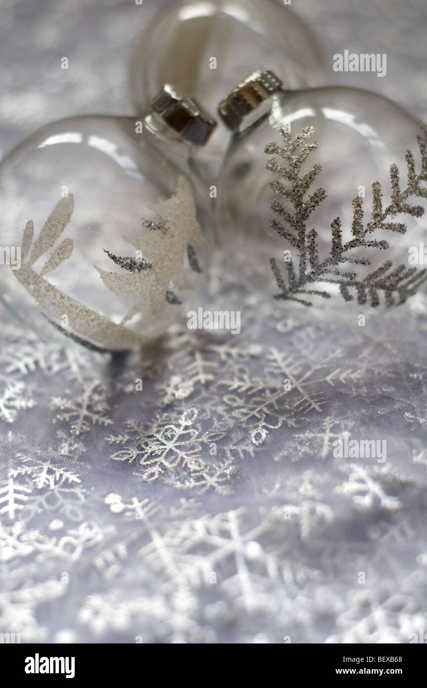 Glass and silver Christmas tree baubles on white and silver colored material Stock Photo