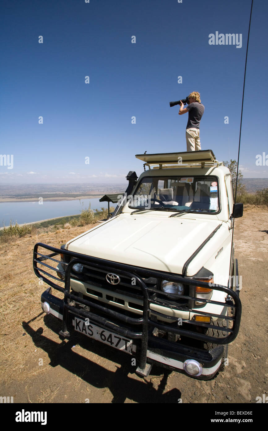 Photographer standing on safari vehicle - Lake Nakuru National Park, Kenya Stock Photo