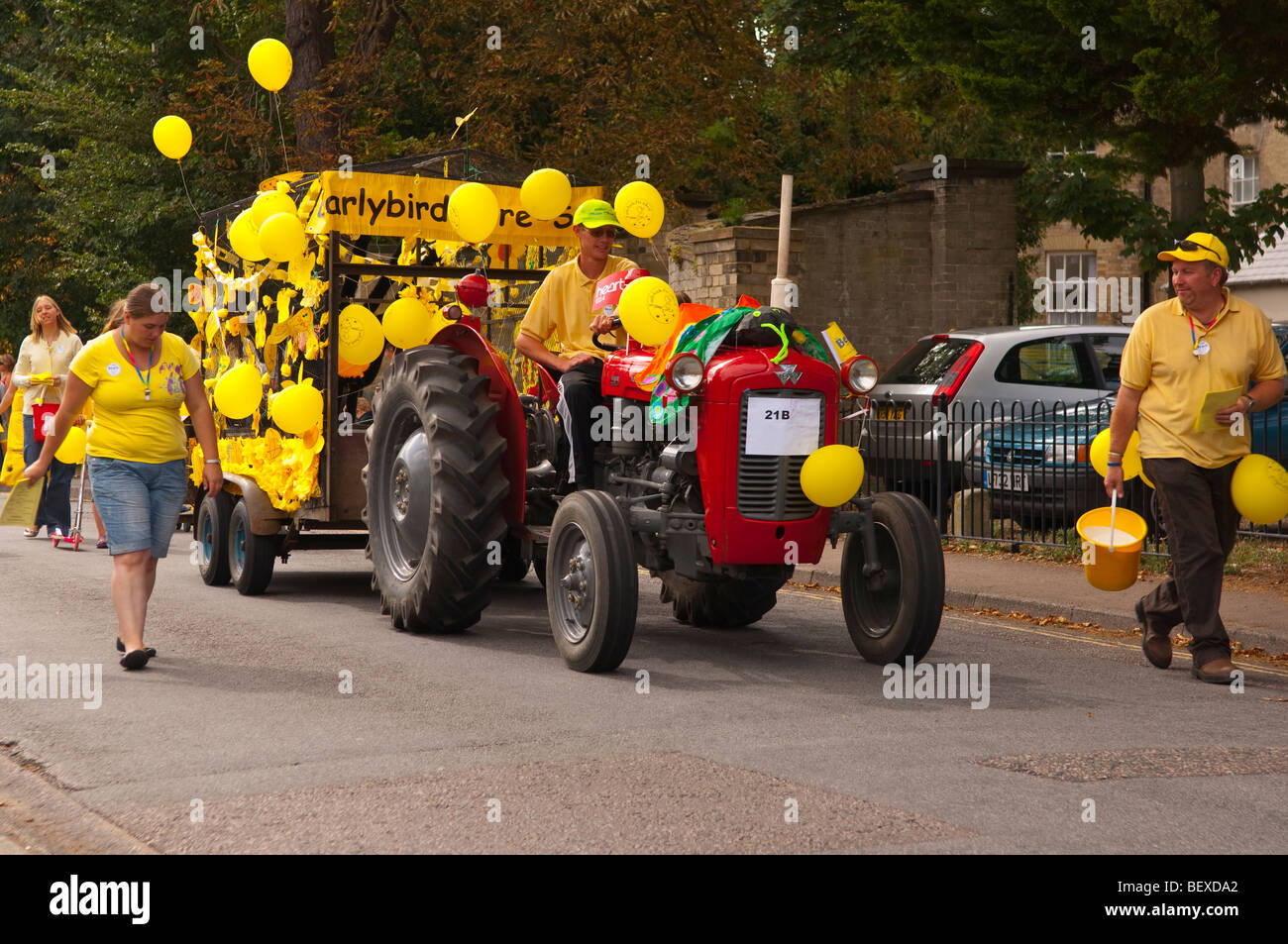 A red tractor with the earlybirds pre-school float being driven in Beccles carnival in Suffolk,uk Stock Photo