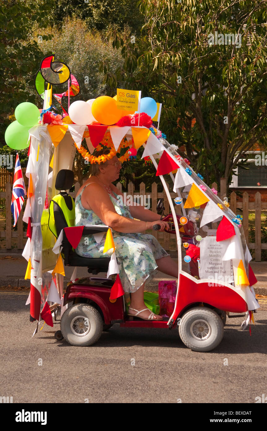 A red mobility scooter being driven in Beccles carnival in Suffolk,uk Stock Photo