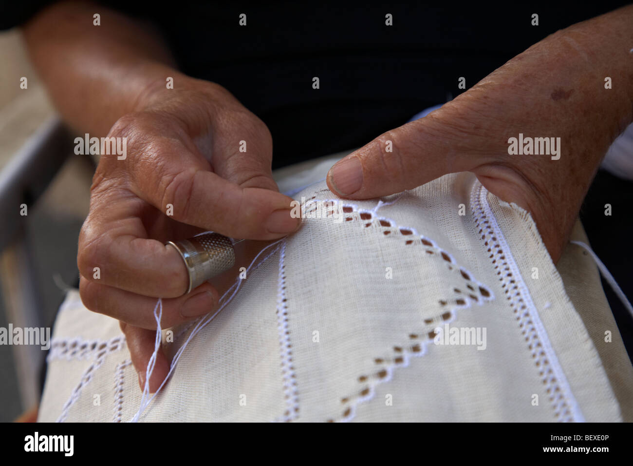 old widow woman sewing traditional lace hand made outside the family shop in pano lefkara republic of cyprus europe Stock Photo