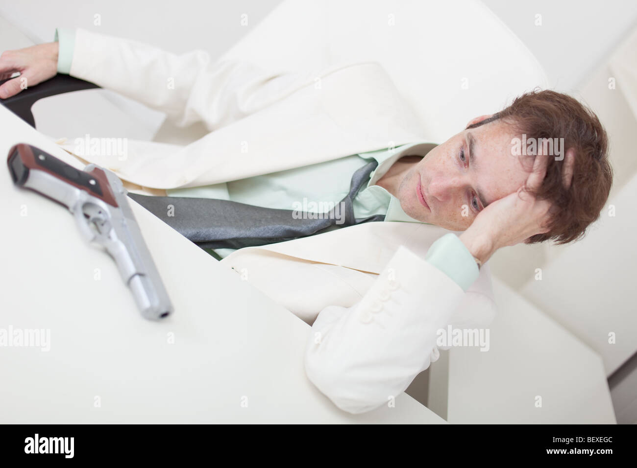 The young businessman reflects on suicide on a workplace Stock Photo