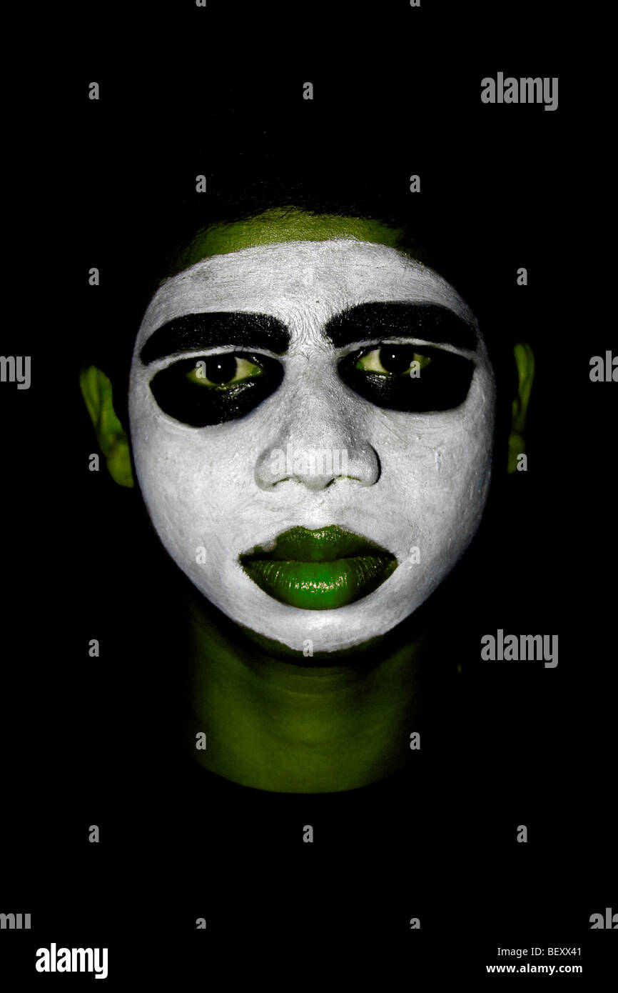 boy with white painted face in black,Indian Tribal look,Tribe,Mime,portrait,street boy,black painted eyes,alien looks Stock Photo