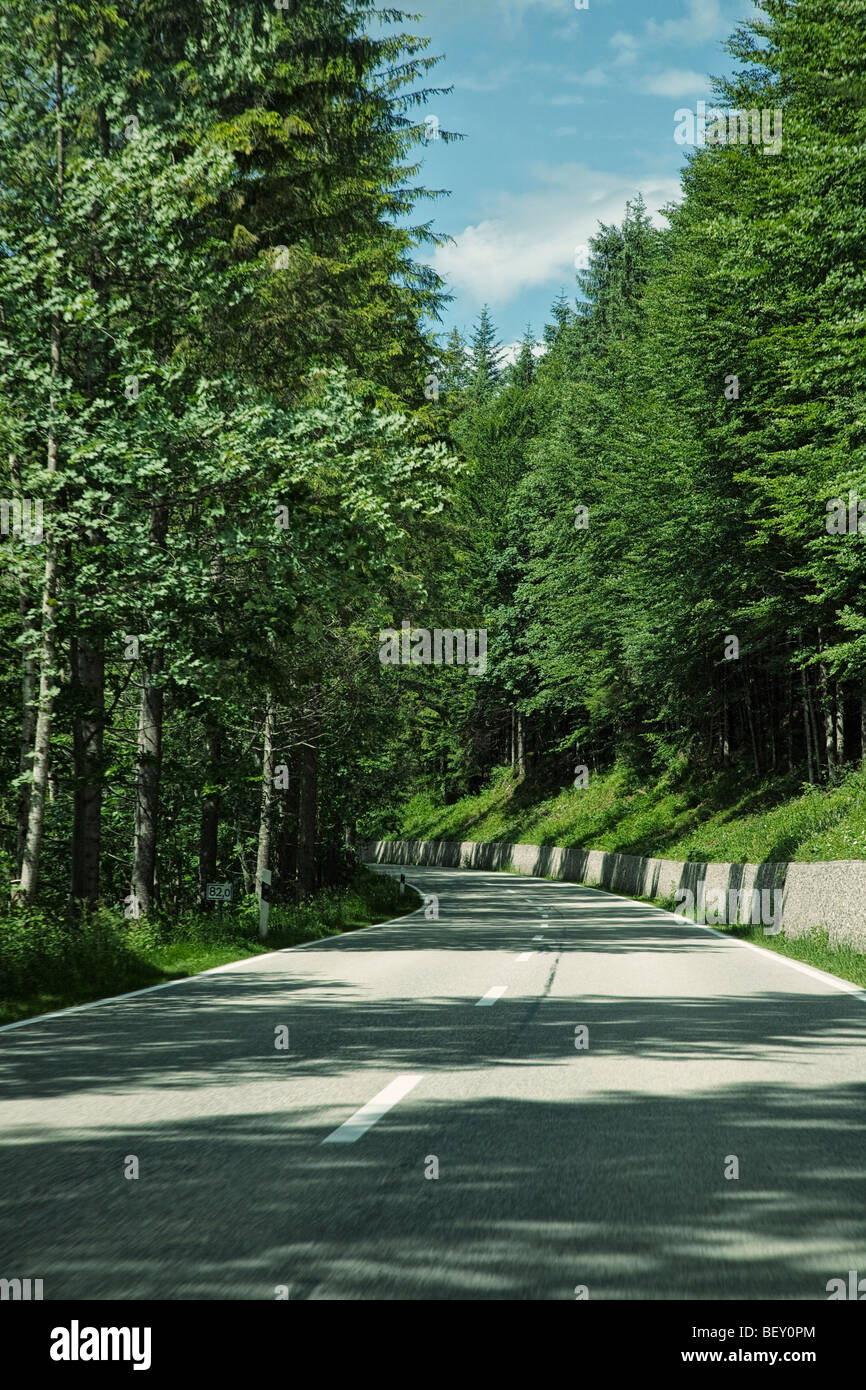 Travelling along an open road through a forest in Bavaria Germany Europe on a road trip Stock Photo