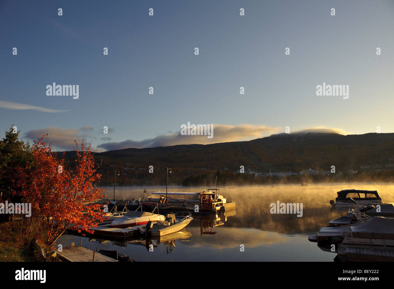 Sunrise on Mt. Tremblant Lake with sailboats and sailboat at marina and