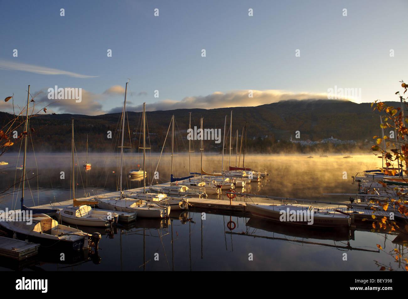 Sunrise on Mt. Tremblant Lake with sailboats and sailboat at marina and