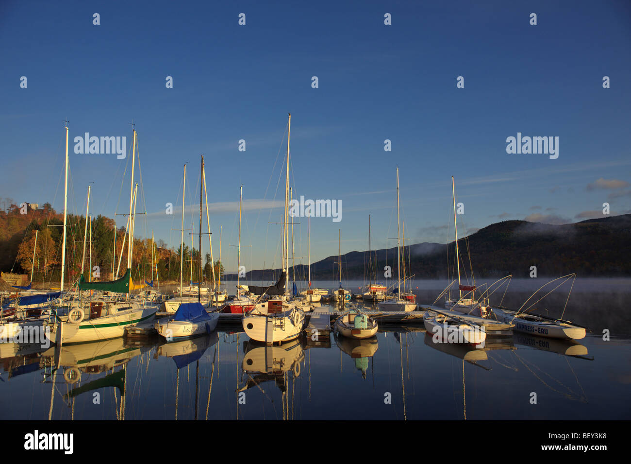 Sunrise on Mt. Tremblant Lake with sailboats and sailboat at marina and