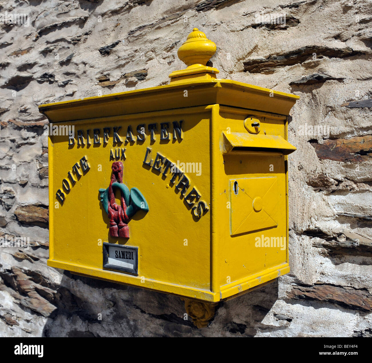 Wall mounted Luxembourg yellow post box, Vianden, Luxembourg. Stock Photo