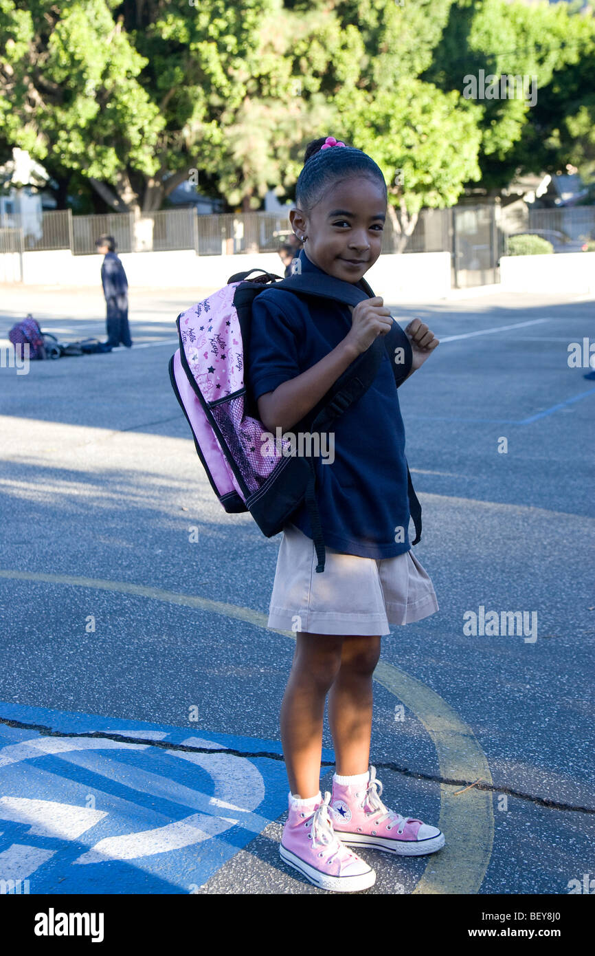 Young Girl in School Yard Wearing a Pink Hello Kitty Back Pack Stock Photo