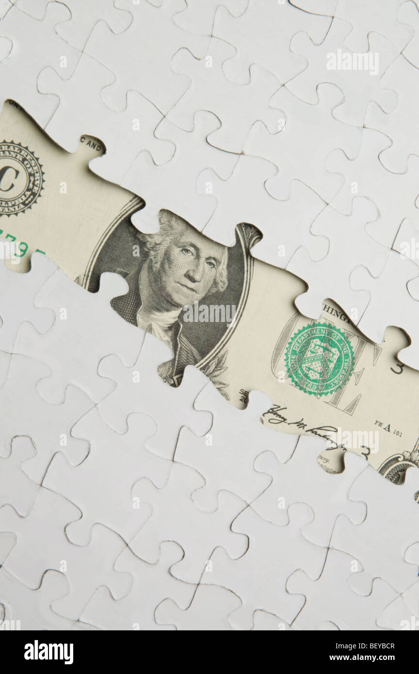Jigsaw puzzle over American dollar bill Stock Photo
