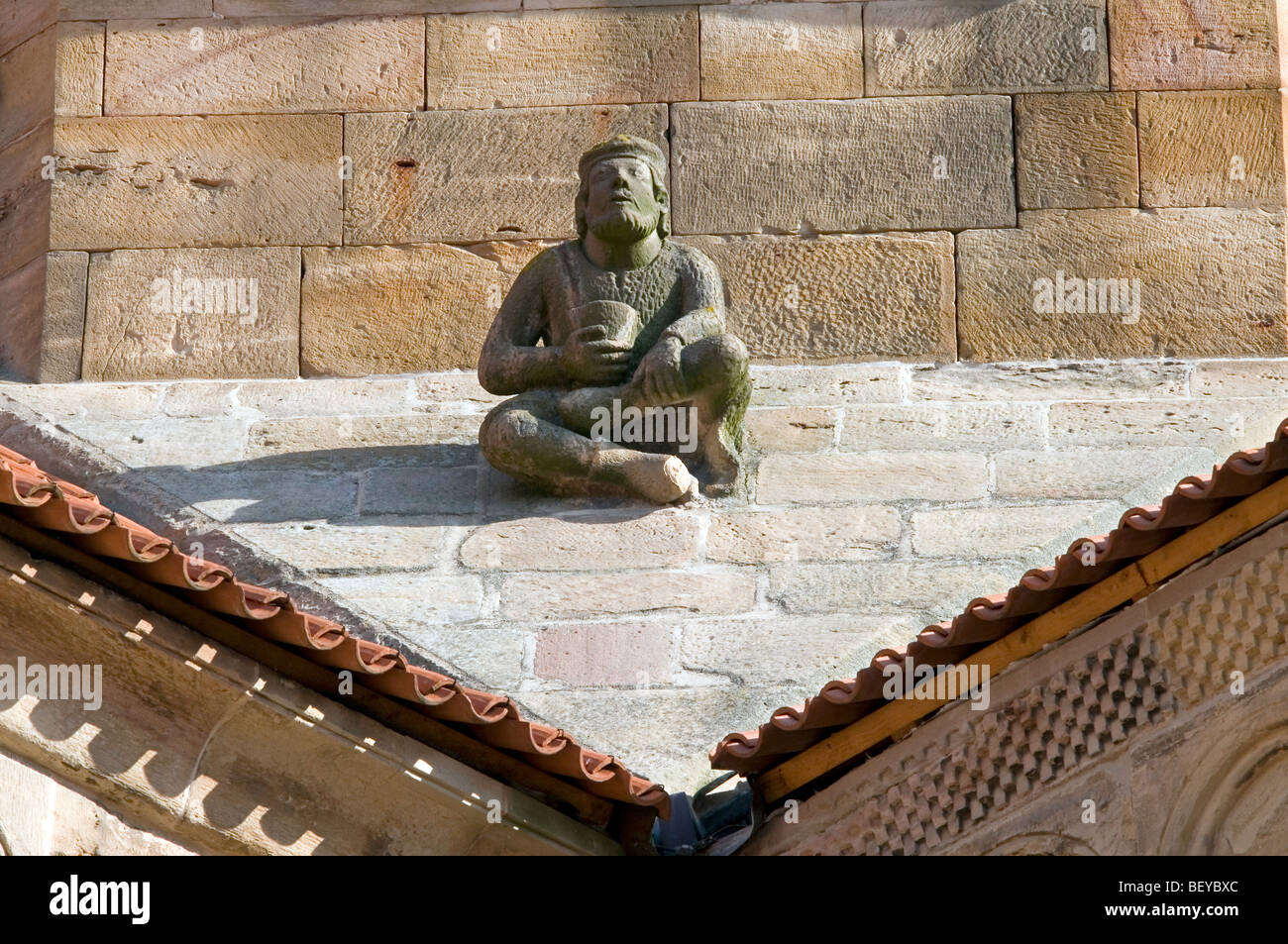 the man sitting on the slope of the roof - the church of saints Peter and Paul in Rosheim - Alsace - France Stock Photo