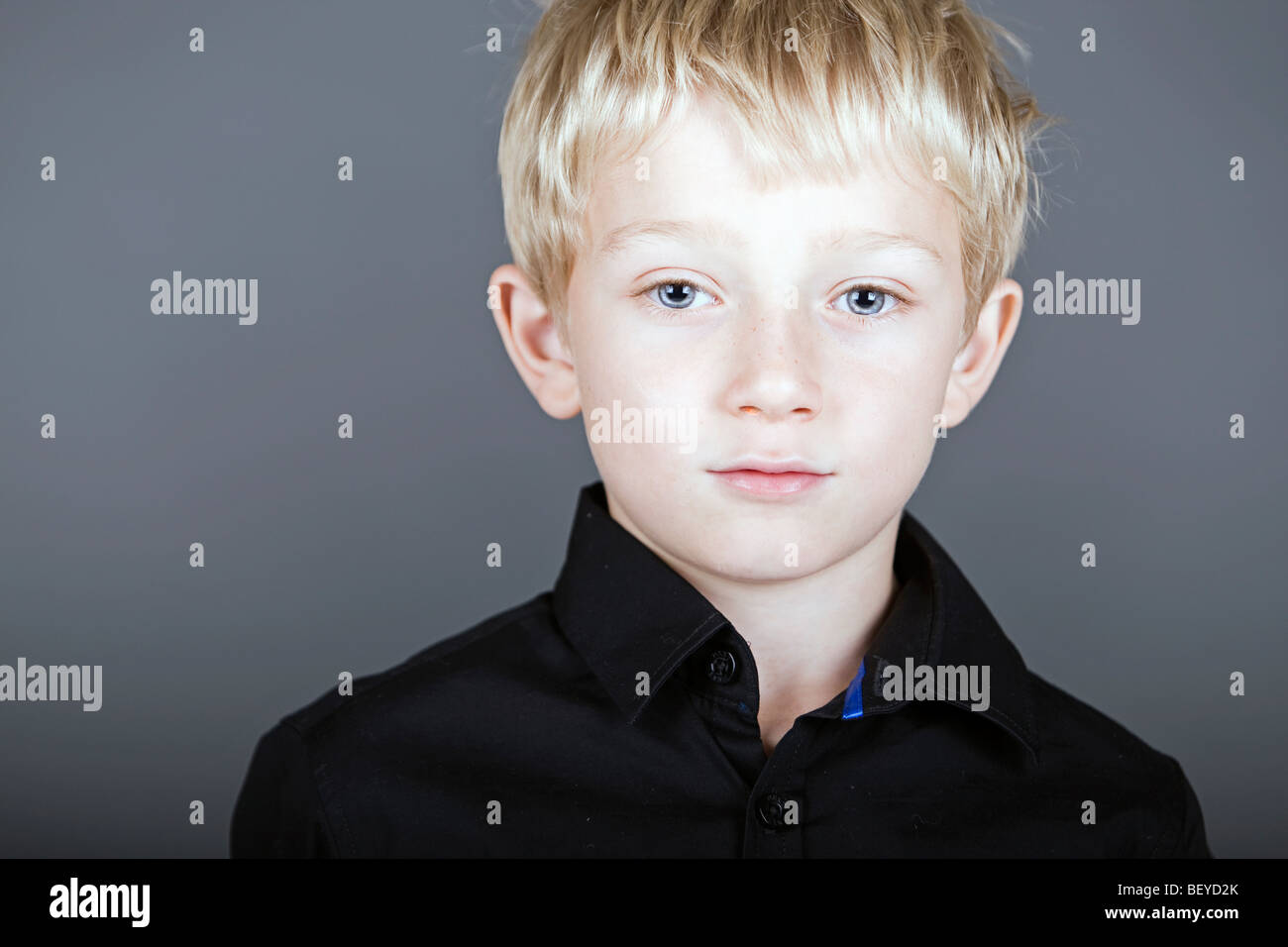 a wary and shy little boy looks concerned Stock Photo