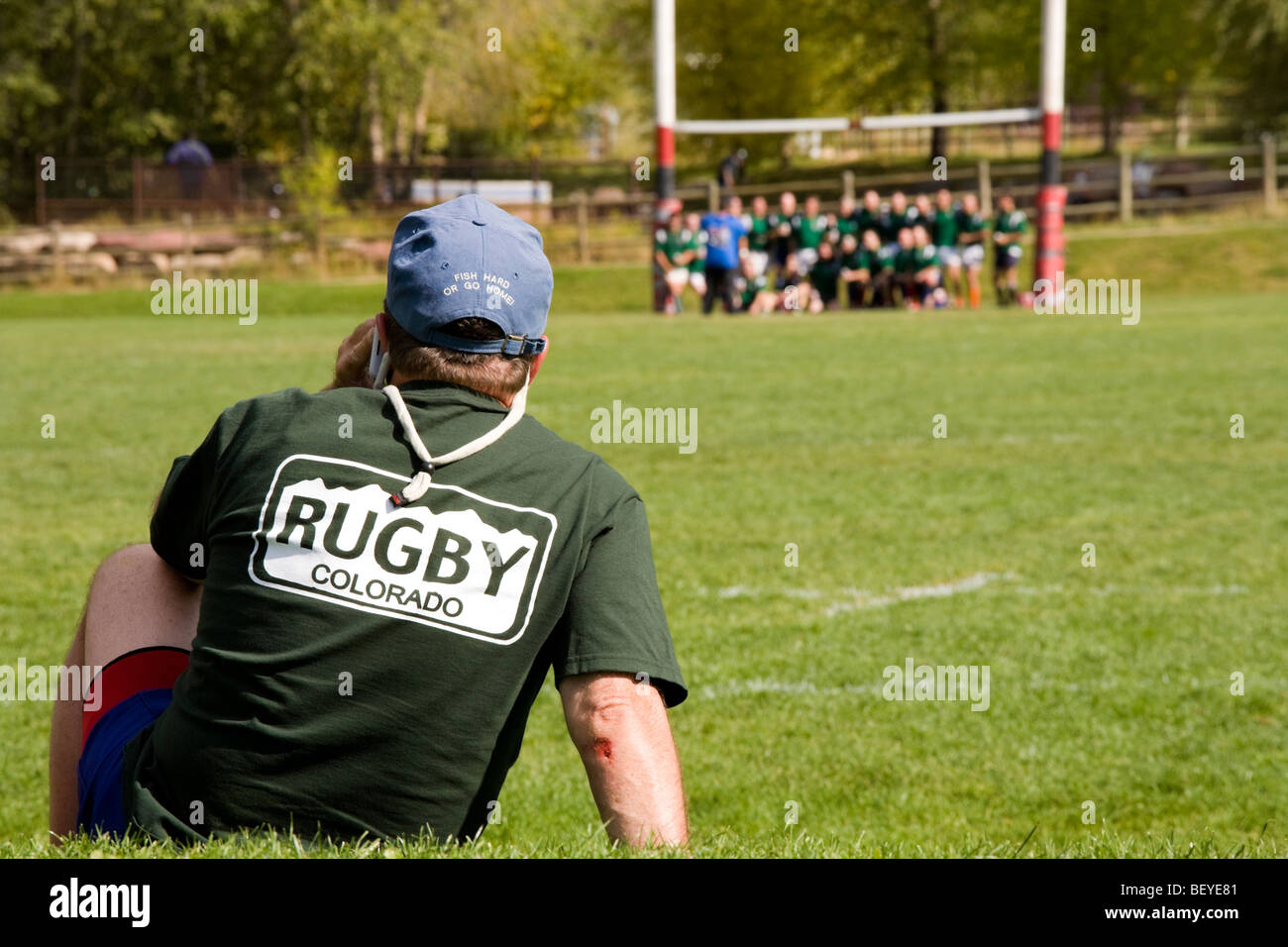 Aspen Colorado 42nd Annual Ruggerfest. Spectator watches as rugby team poses for a group shot. Stock Photo
