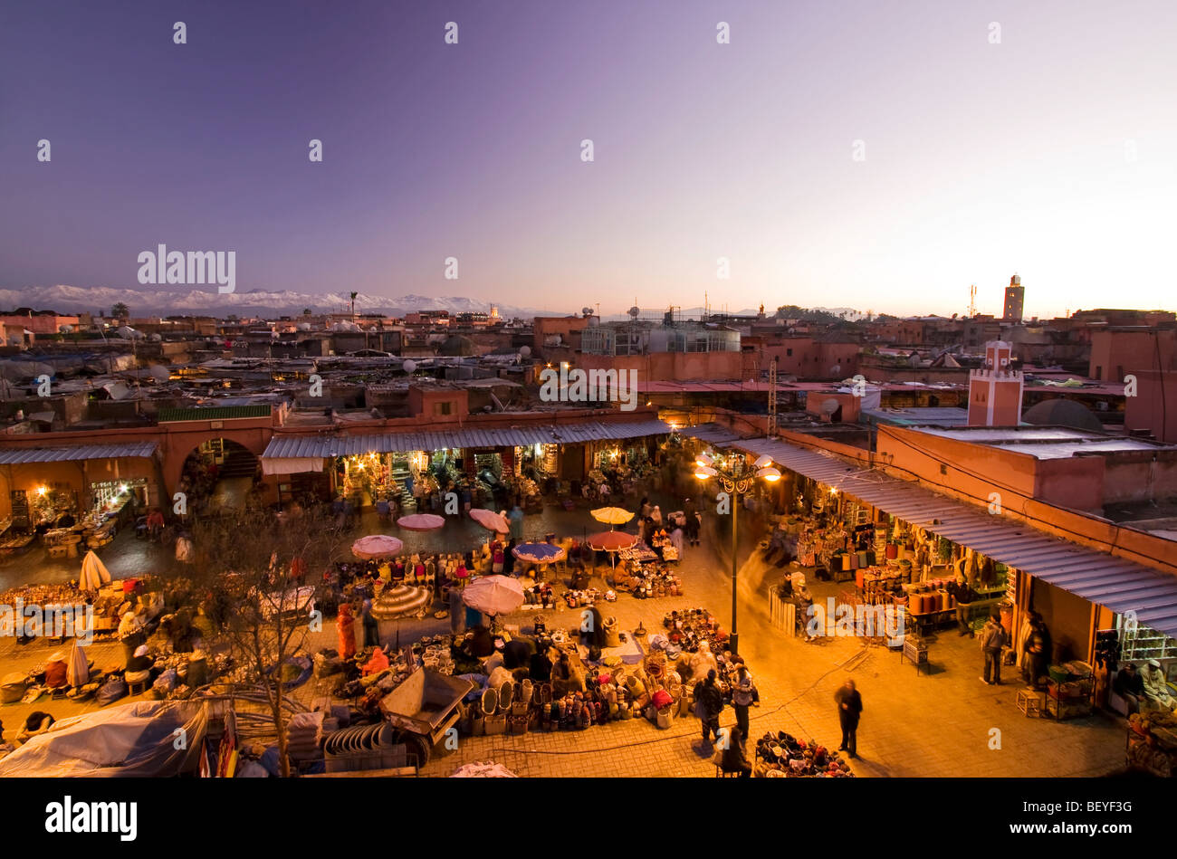 Urban landscape. View from top of Marrakesh medina at dusk, with bazaar, market and the Atlas snowy mountain in the background Stock Photo