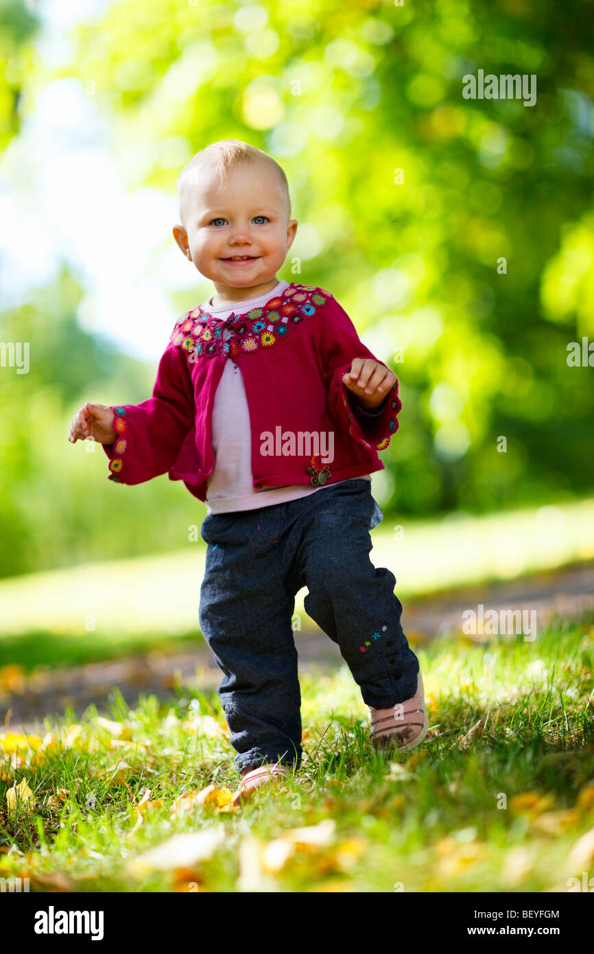 Cute 1 year old baby girl walking outdoors Stock Photo