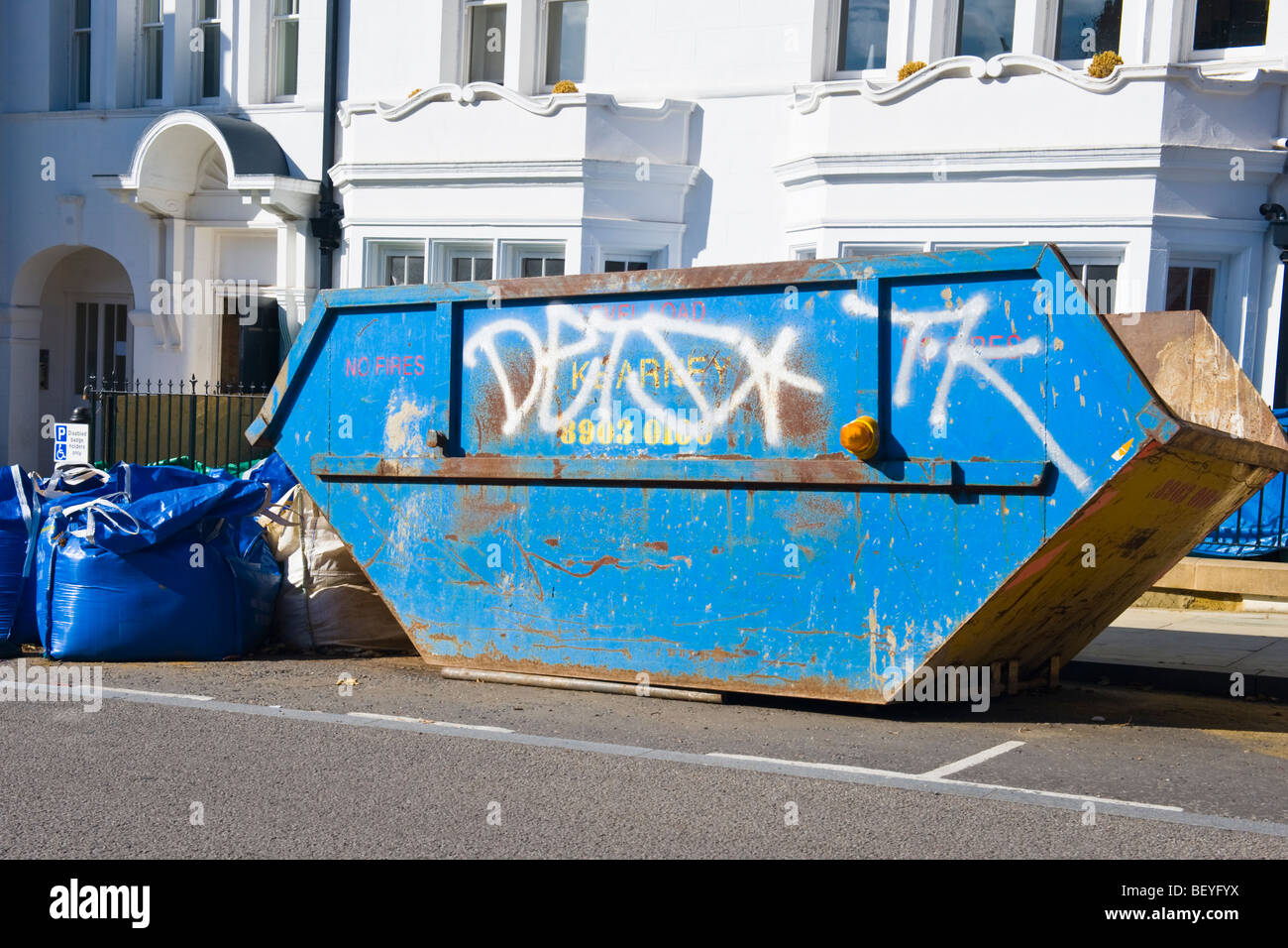 Harrow on the Hill , blue skip with graffiti parked in disabled parking