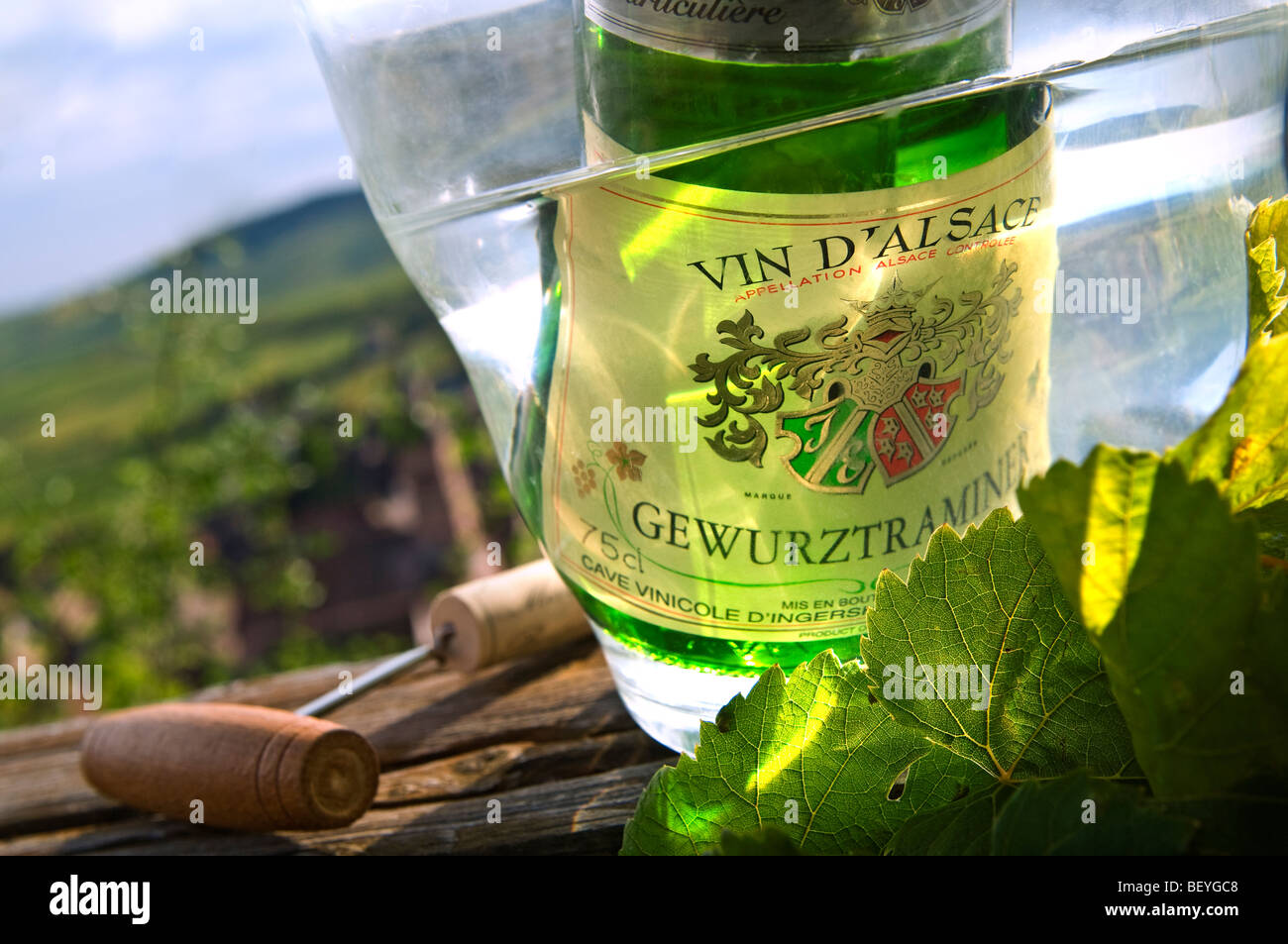 Gewurztraminer wine bottle in cooler with cork and corkscrew  Riquewihr wine village and vineyards in background Alsace France Stock Photo