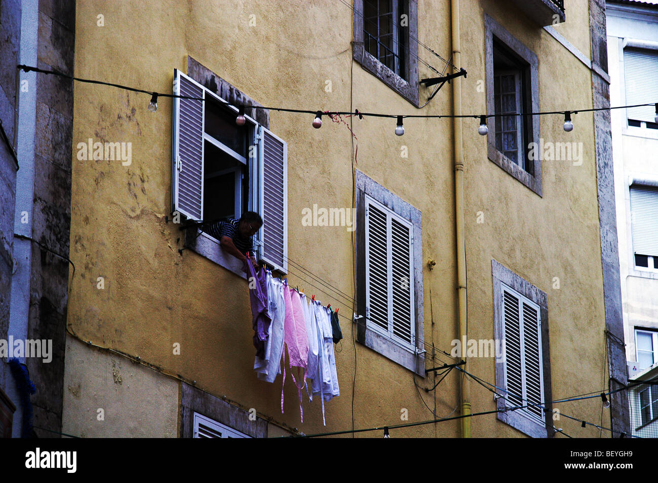 Lisbon lady hanging her clothes Stock Photo