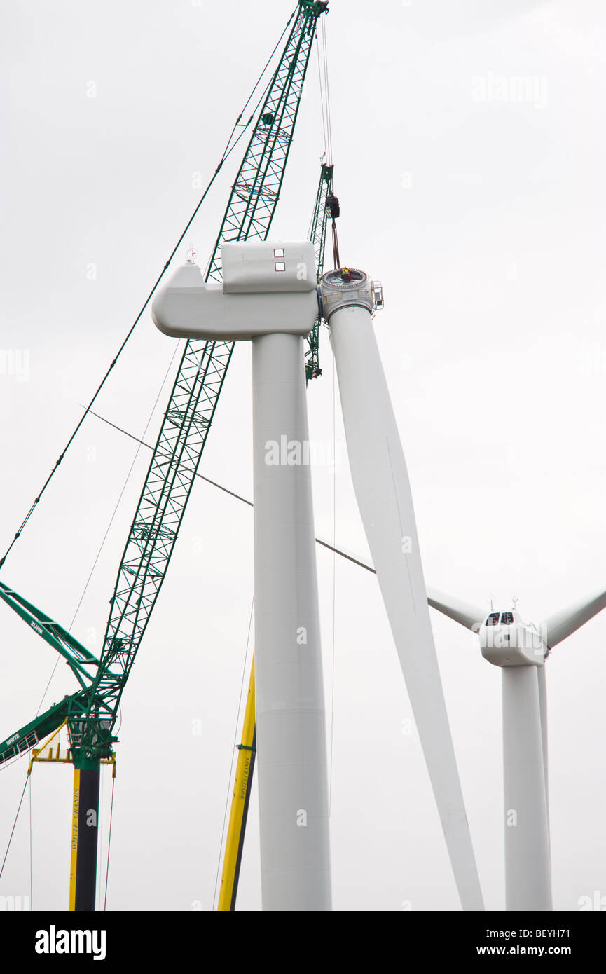 Blades being lifted by cranes for fitting on Nordex N90 wind turbine under construction at