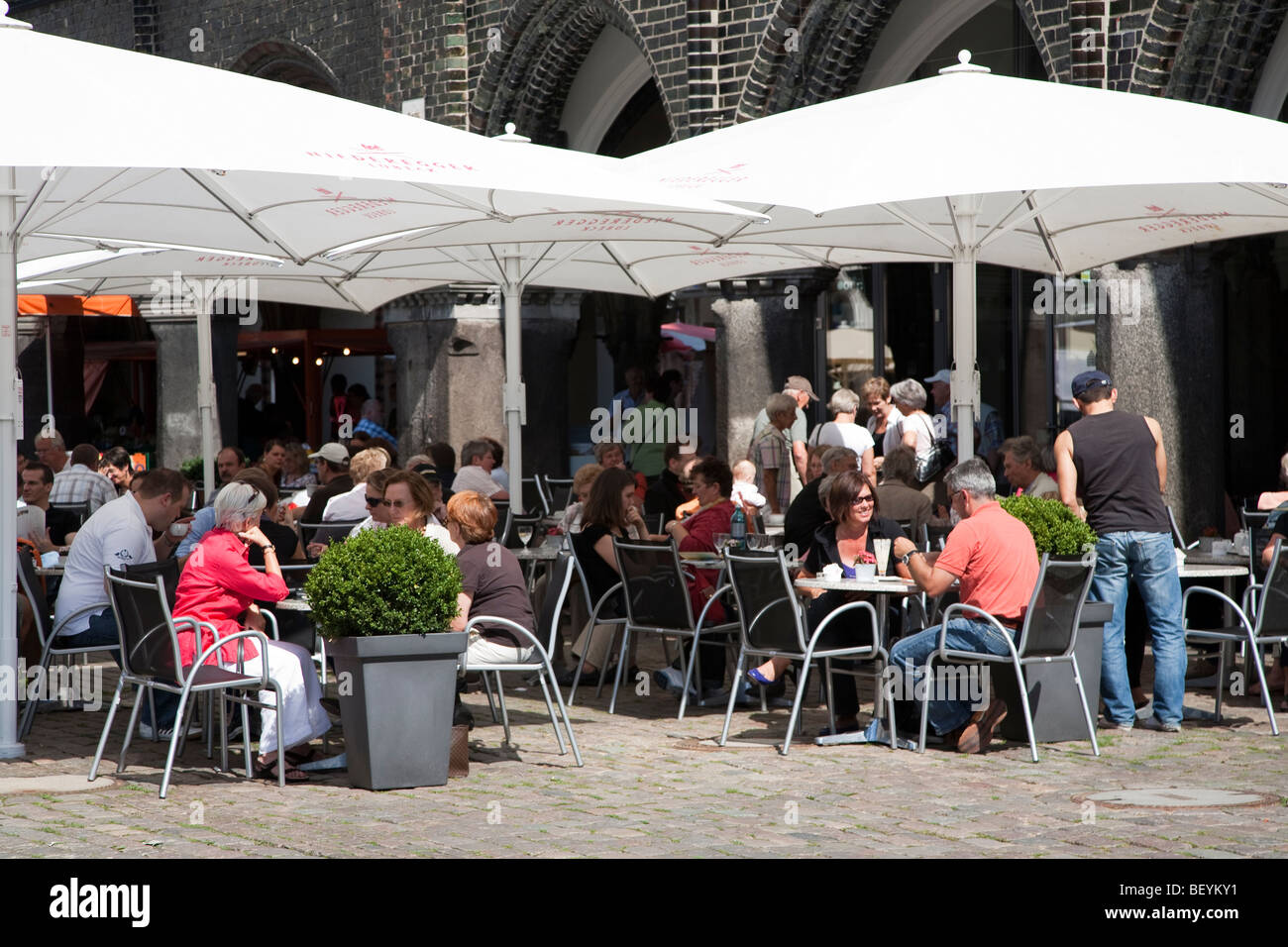 People at pavement bar outside the town hall Lubeck Germany Stock Photo