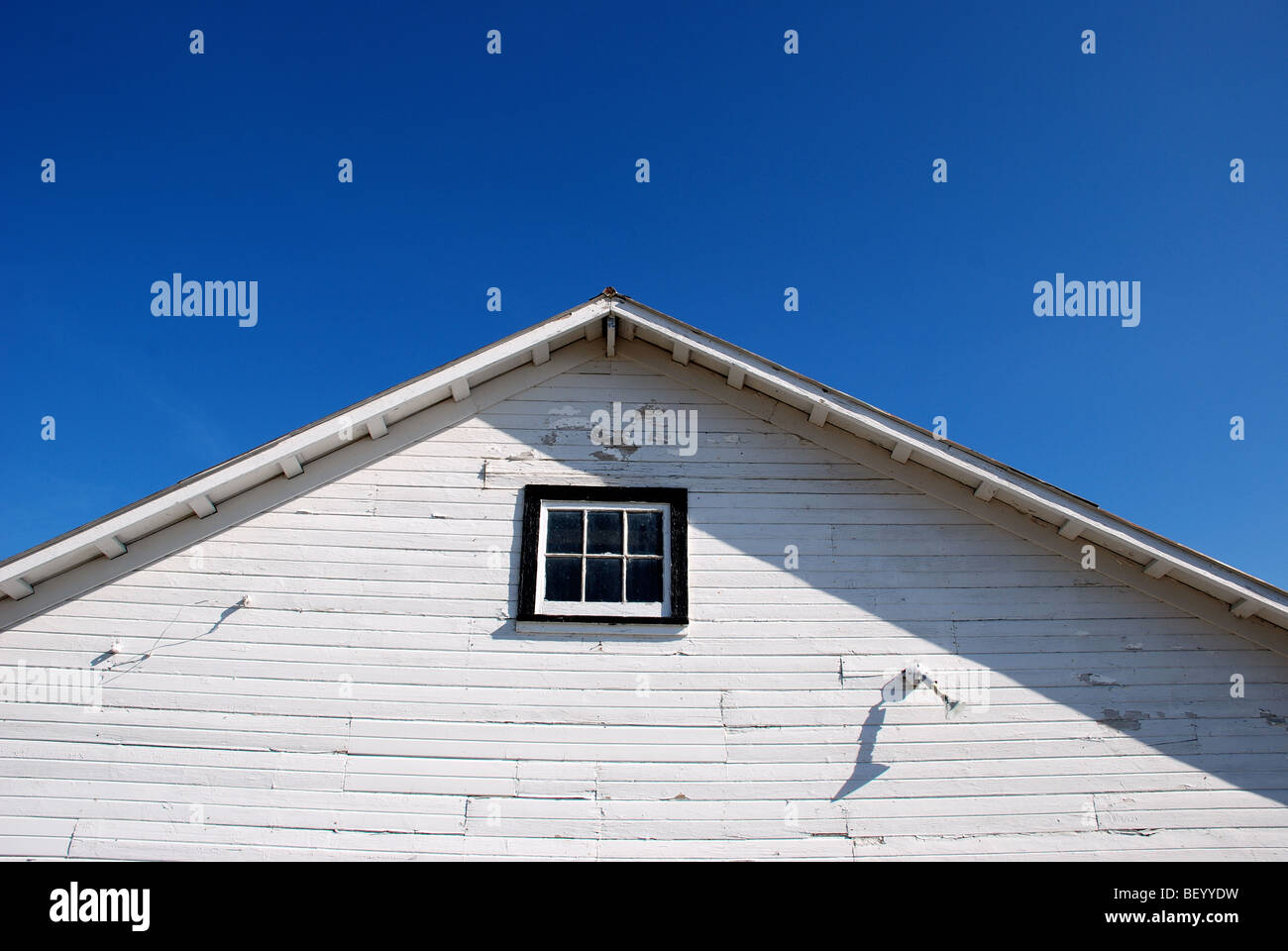 White barn under blue skies Stock Photo