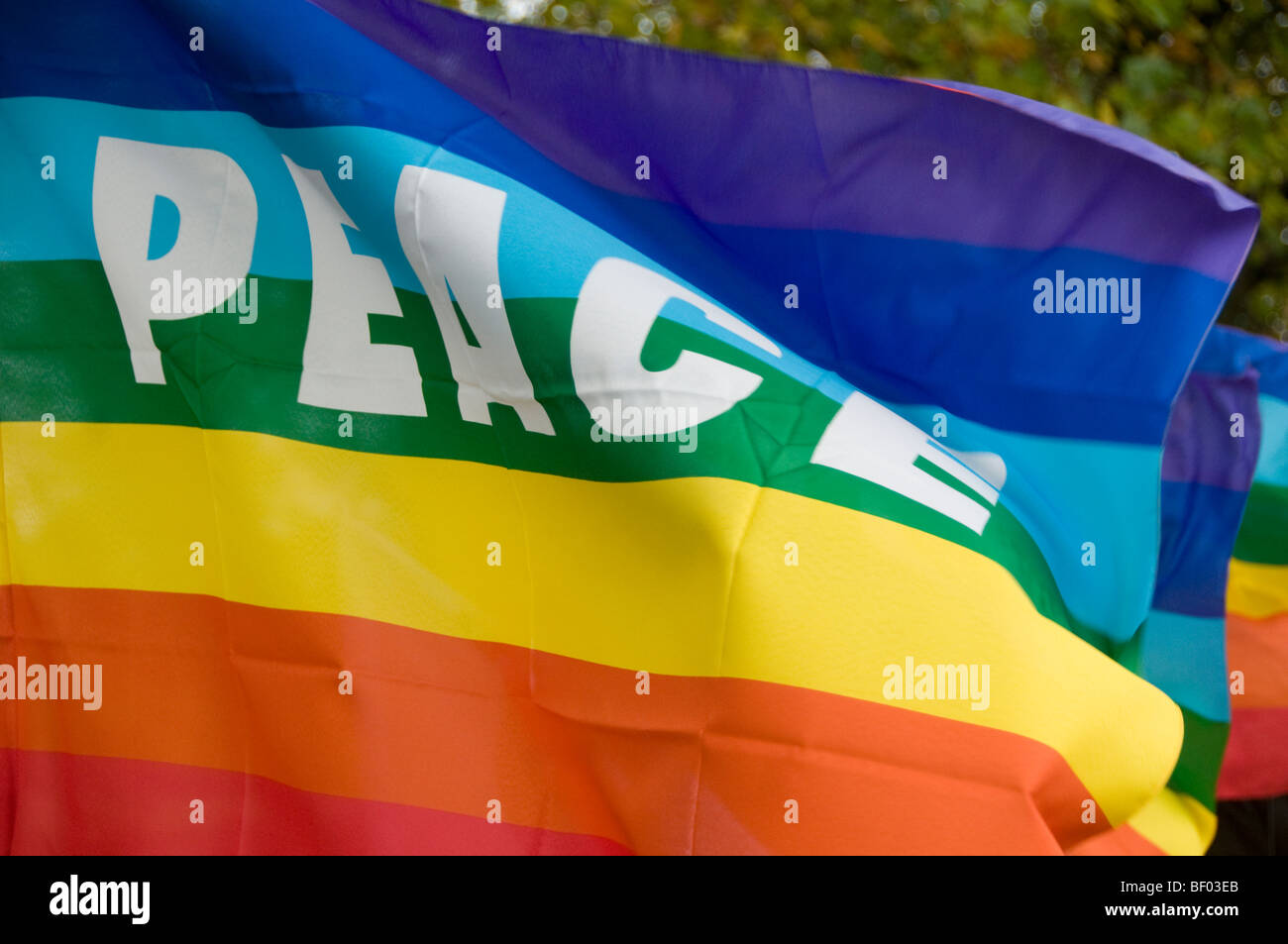 Anti war demo - bring the troops home from Afghanistan. Rainbow coloured Peace flag Stock Photo