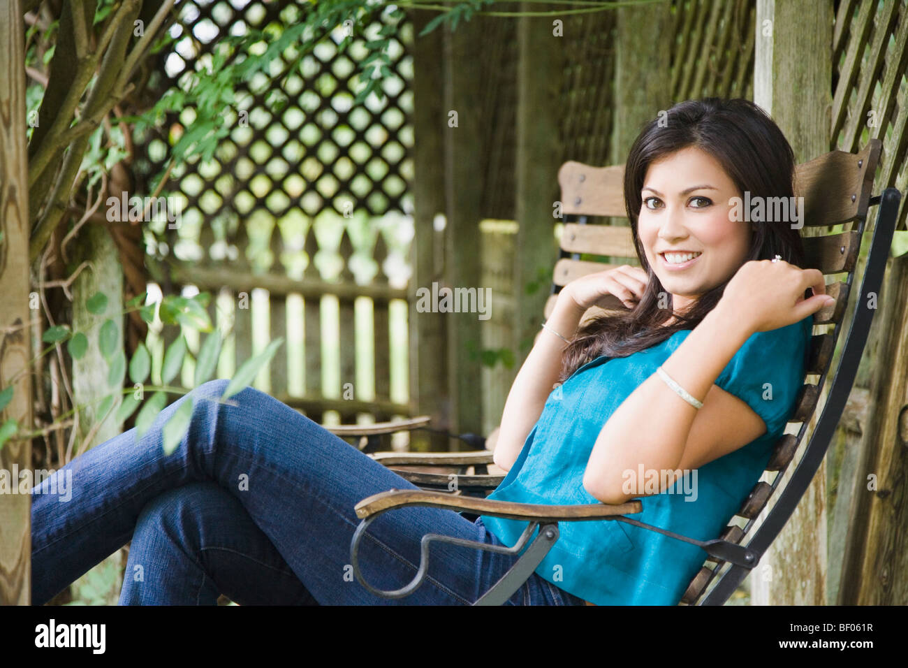 Happy woman sitting on a chair and smiling Stock Photo - Alamy