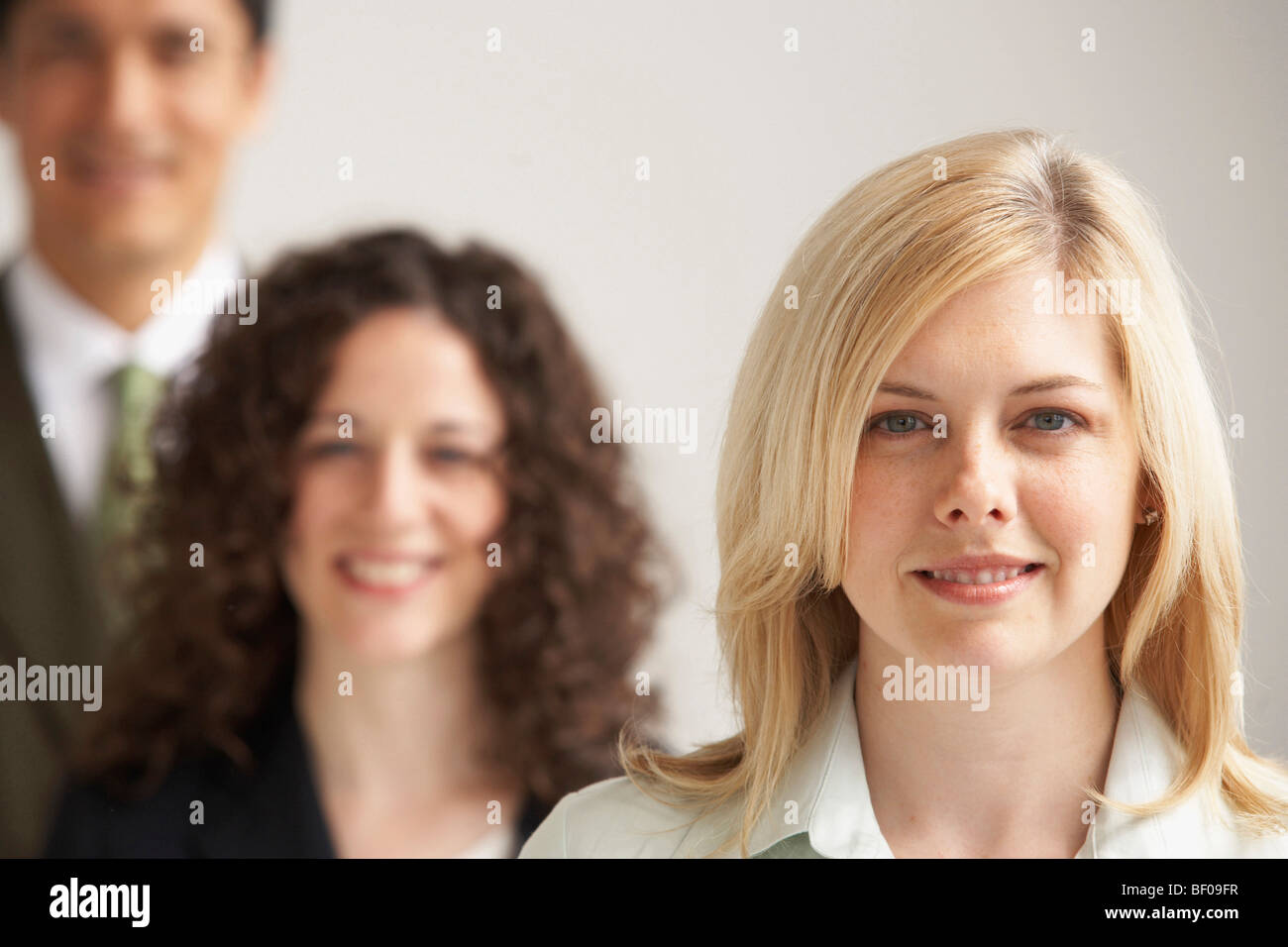 Portrait of two businesswomen and a businessman smiling Stock Photo - Alamy