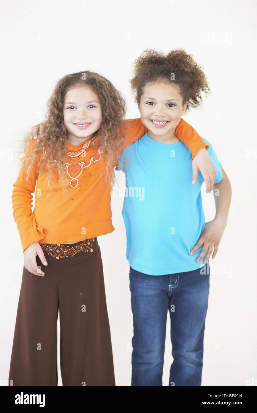 Portrait of two girls smiling with their arms around each other Stock Photo
