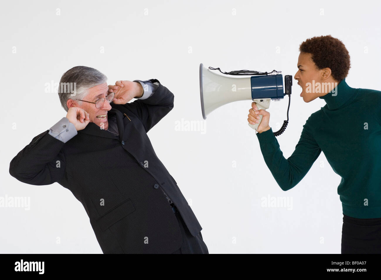 Businesswoman using a megaphone and shouting at a businessman Stock Photo