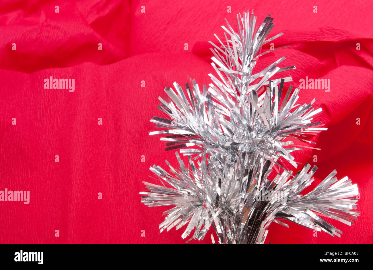 Silver tinsel abstract against red crepe paper christmas background image Stock Photo Alamy