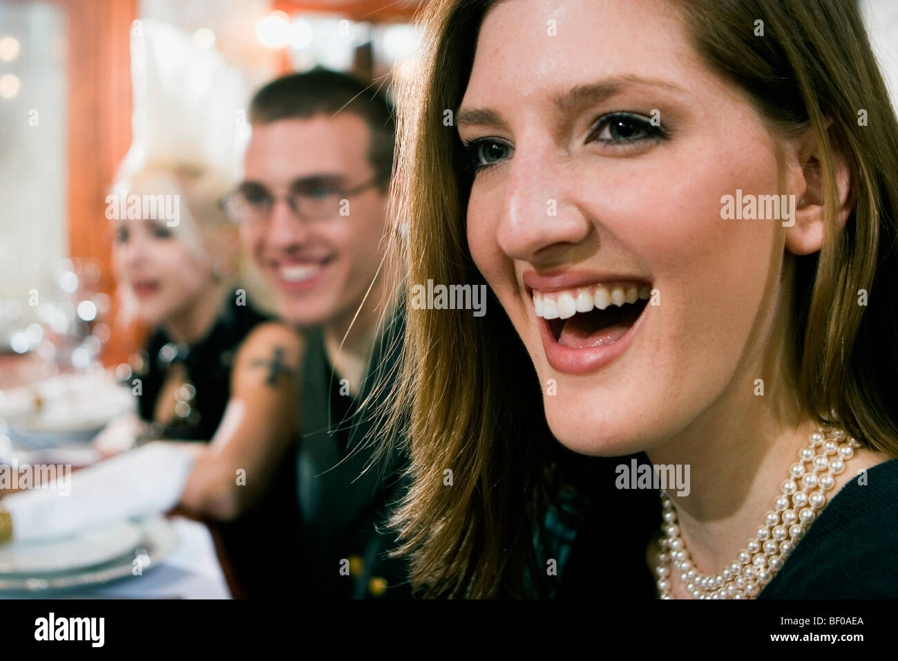 Two young women and a young man smiling Stock Photo - Alamy