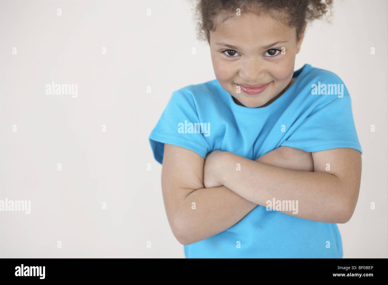 Portrait of a girl with her arms crossed smiling Stock Photo - Alamy