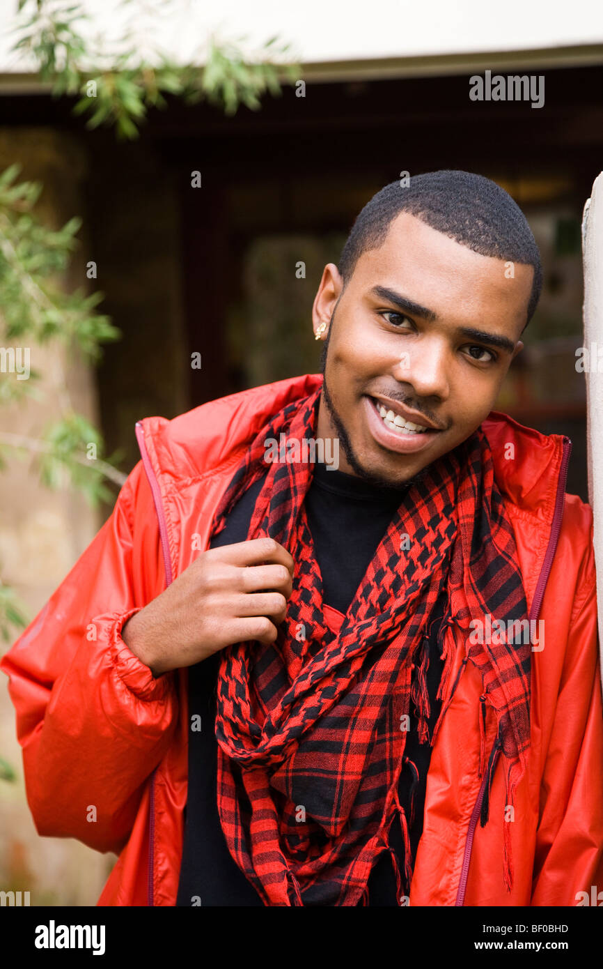 Portrait of a man leaning against a wall and smiling Stock Photo - Alamy