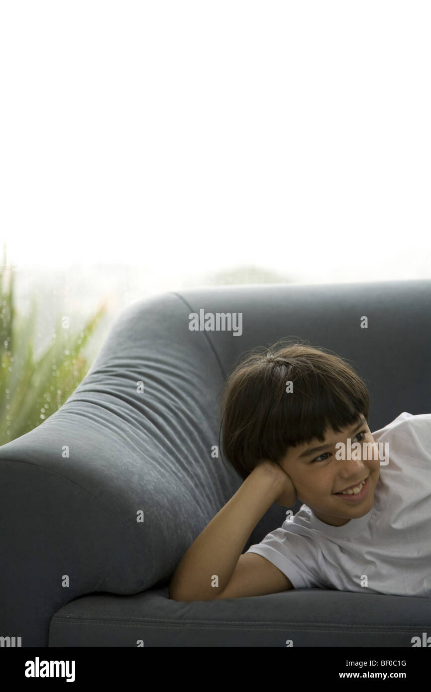 Boy lying on a couch Stock Photo