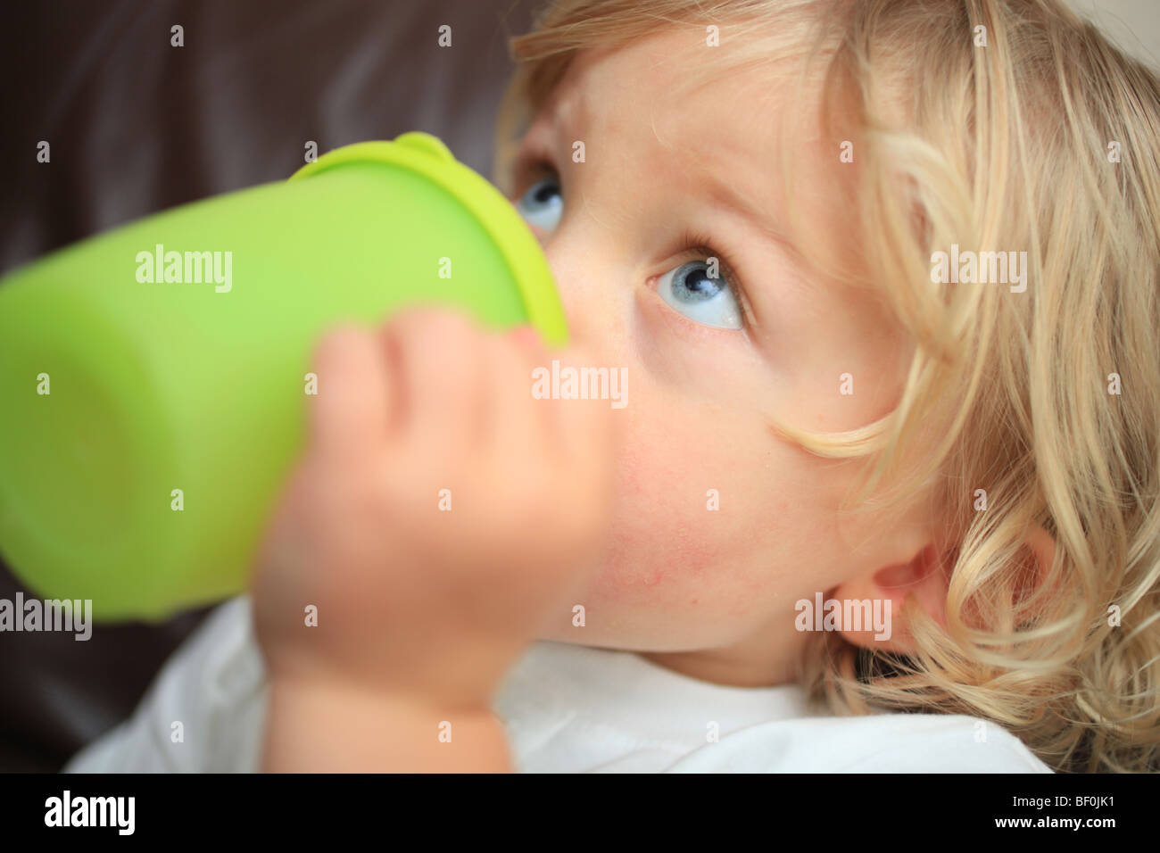 Toddler drinking from a beaker Stock Photo Alamy