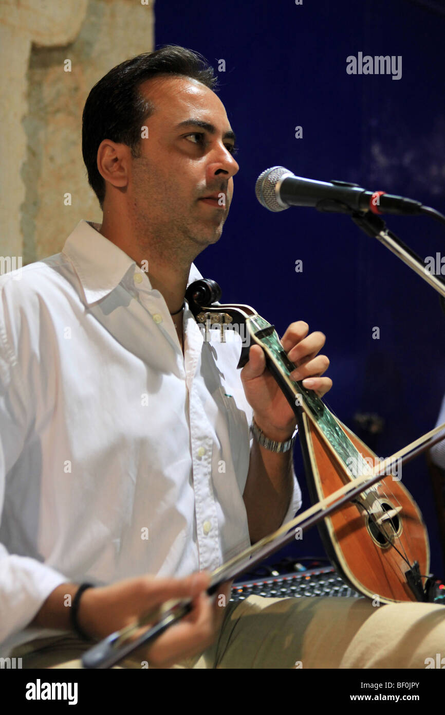 A musician performing on the Cretan three-stringed lyra at a street party in Prines, Crete, Greece. Stock Photo