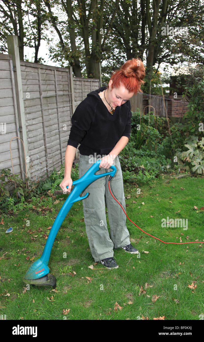 Woman using a strimmer Stock Photo Alamy