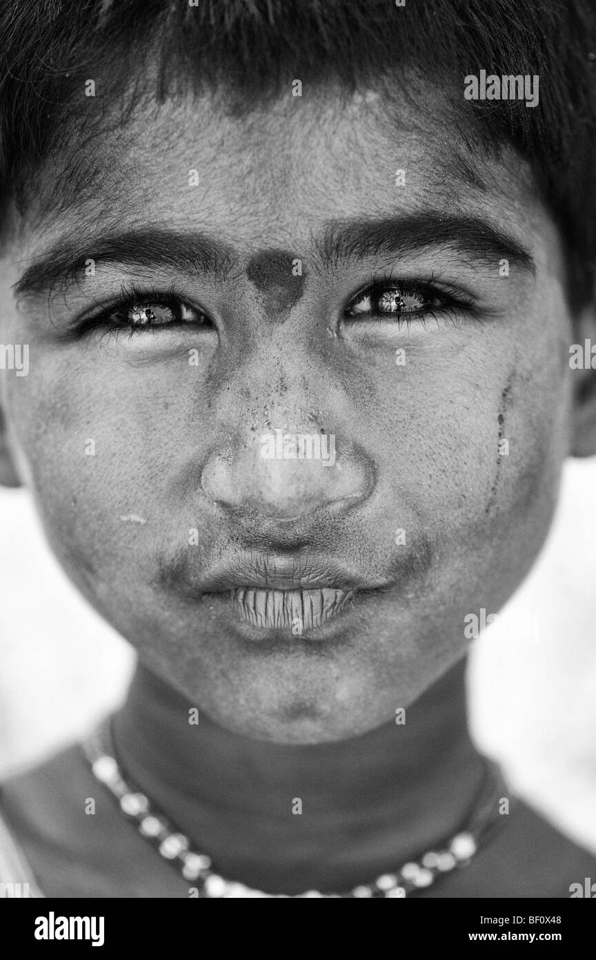 Poor young Indian street girl staring at camera portrait. Monochrome selective focus Stock Photo