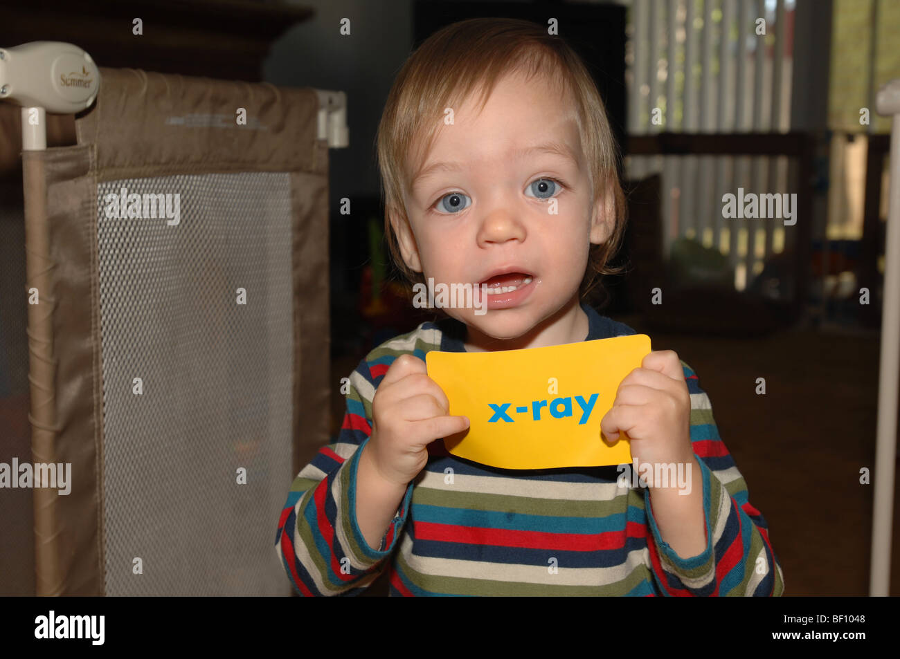 A young boy holds up a sign with the word XRAY Stock Photo Alamy