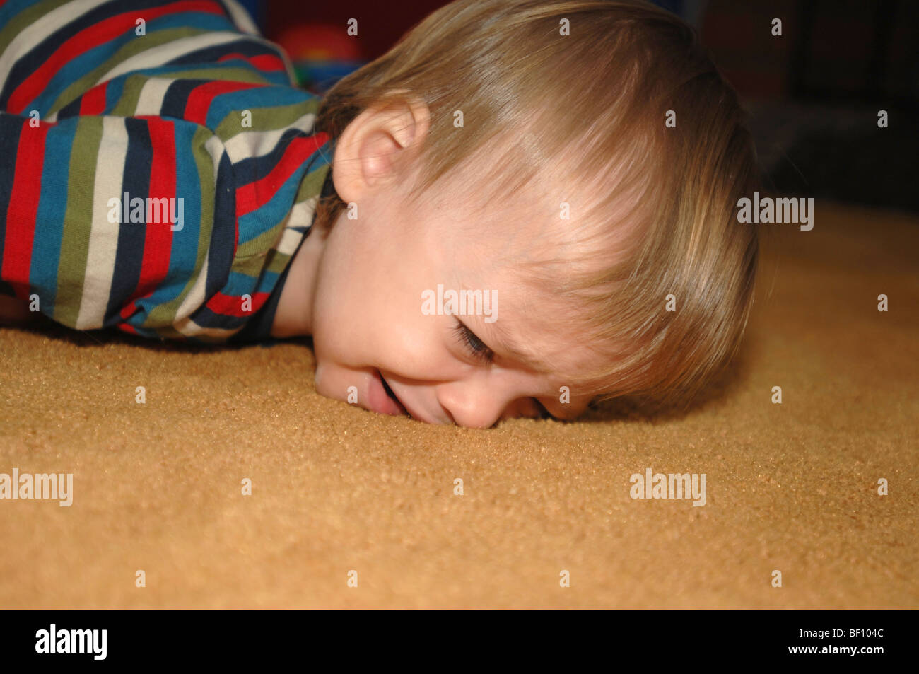 A young child falls onto the carpet Stock Photo Alamy