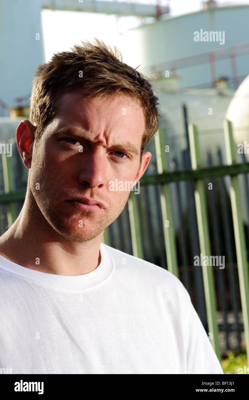 25 - 30 year old man alone looking stern at the camera, confrontational quizzical Stock Photo