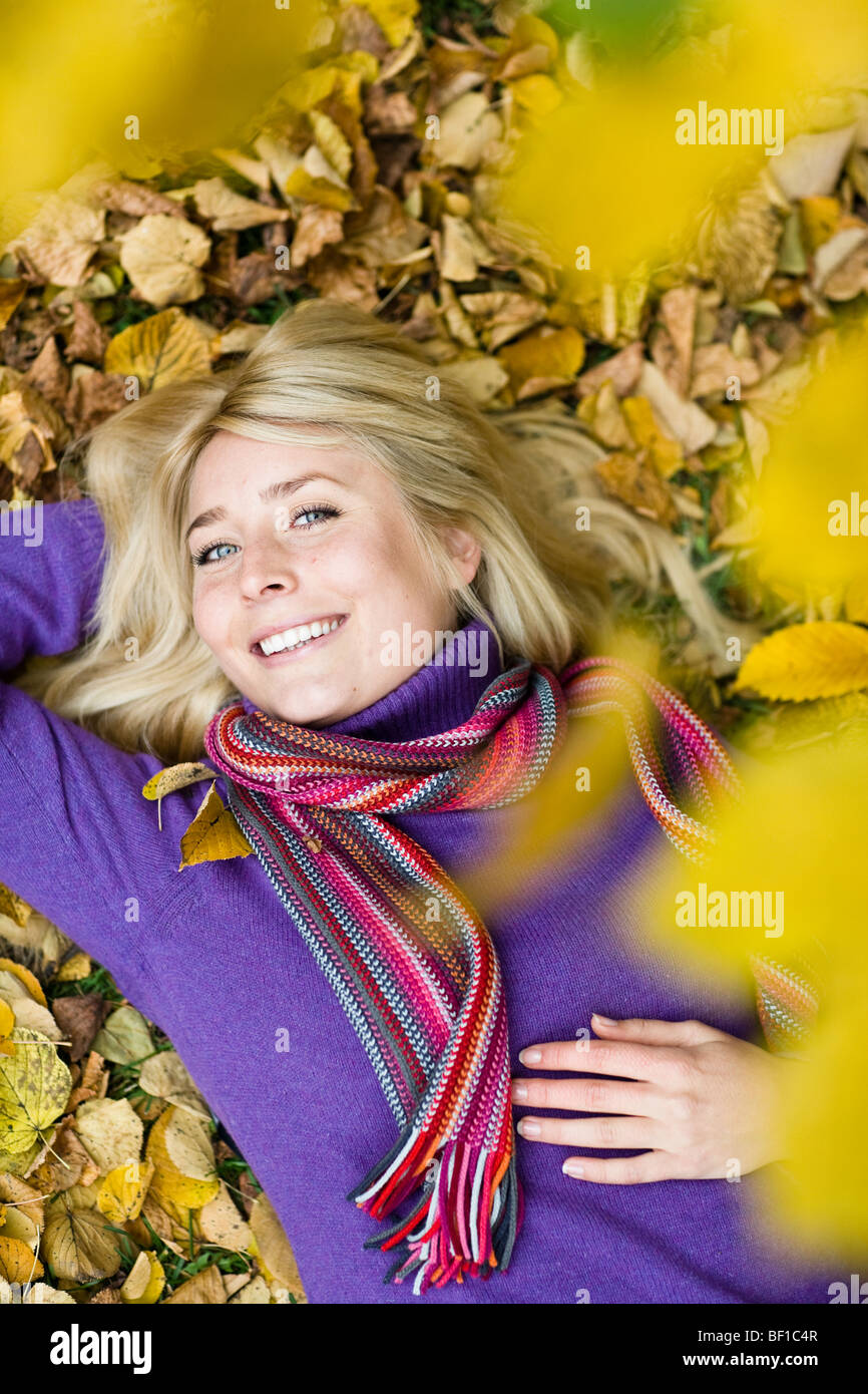 A woman resting on autumn leaves, Sweden. Stock Photo