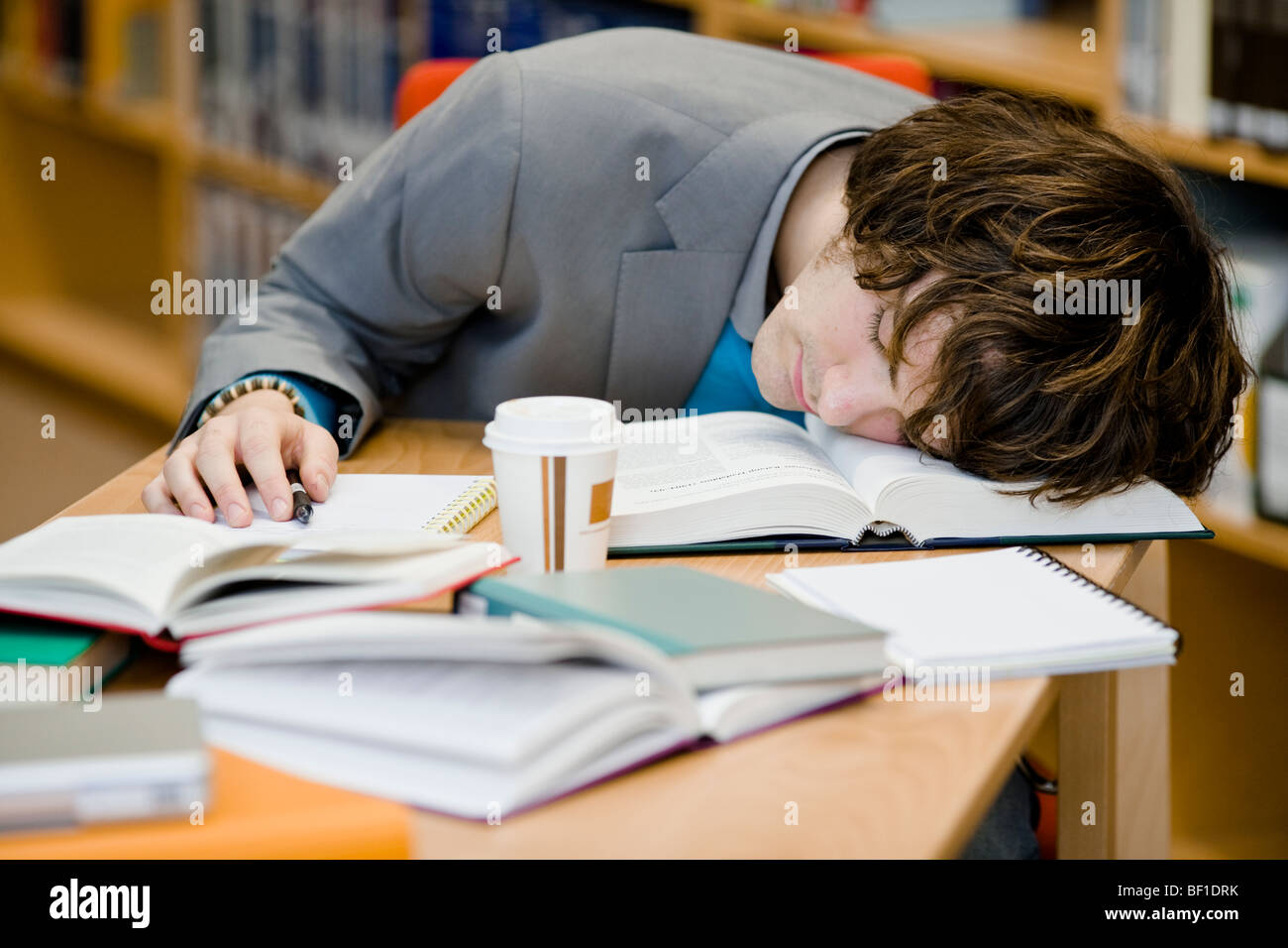 A student who has fallen asleep in a library, Sweden. Stock Photo