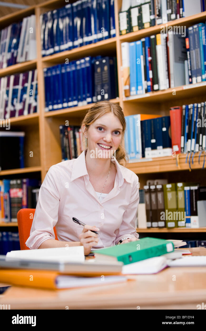 A female student studying in a library, Sweden. Stock Photo