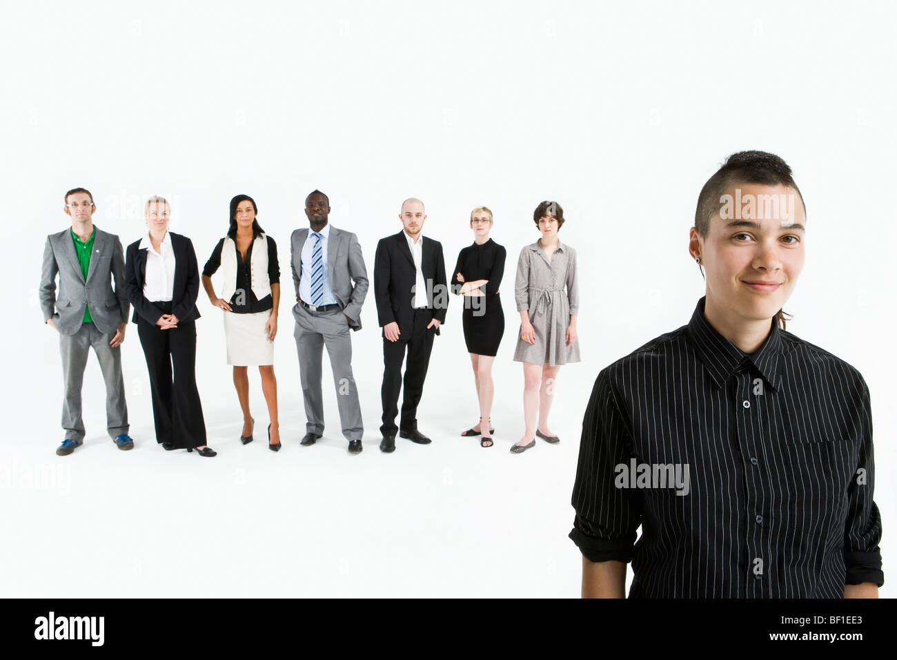 A young professional in front of a row of business people Stock Photo