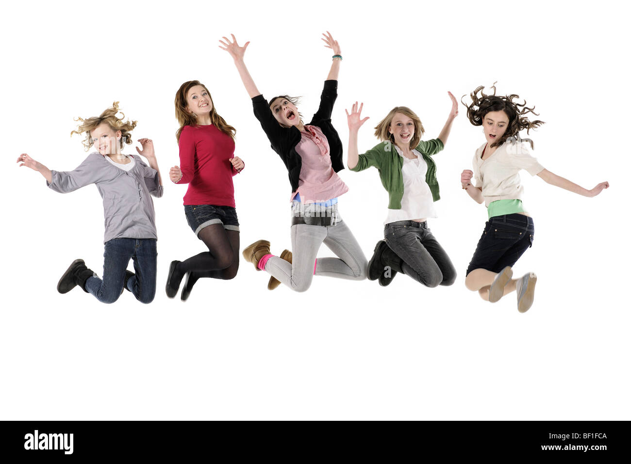 Five teenage girls jumping in the air against white background Stock Photo
