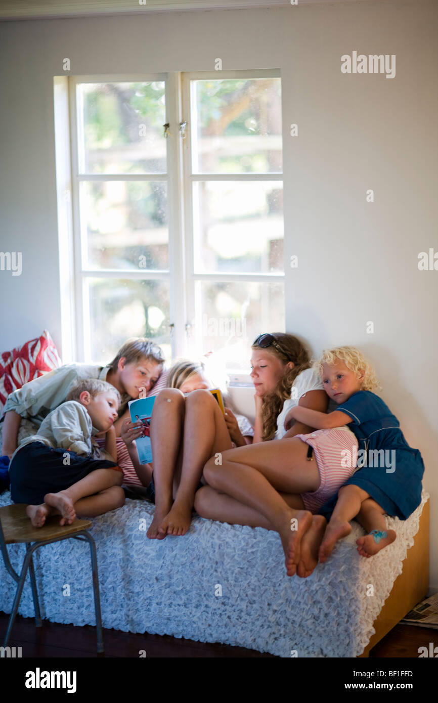 Children at different ages in a bed, Sweden. Stock Photo