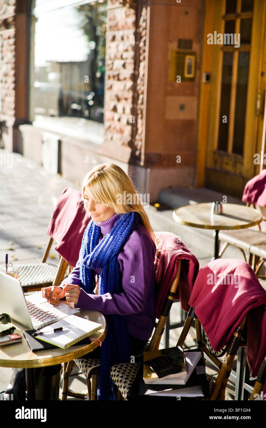 Young woman sitting in a cafe using a laptop, Sweden. Stock Photo
