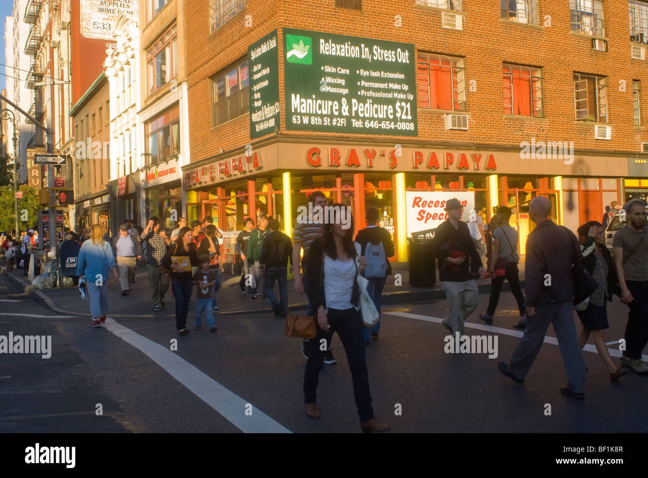 Pedestrians cross Eighth Street at Sixth Avenue in Greenwich Village in New York Stock Photo